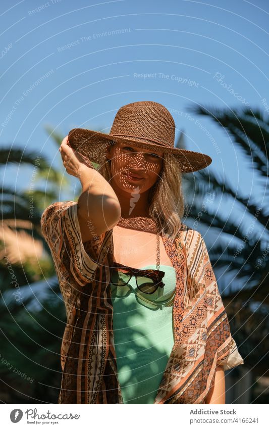 Serene traveler resting in sunlight against blue sky woman resort tourist blond vacation idyllic freedom harmony looking at camera female summer relax peaceful
