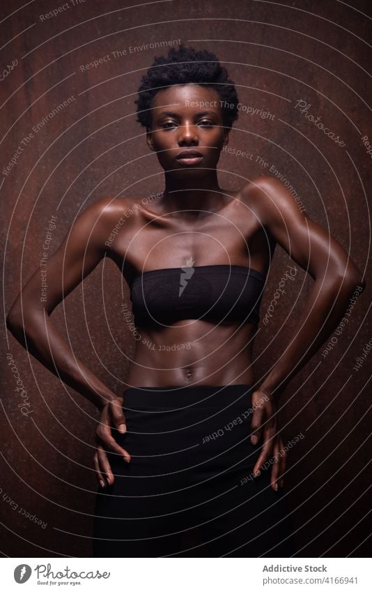 Alluring black woman standing in dark studio model seductive allure grace slender feminine temptation sensual vogue appearance fit beautiful attractive