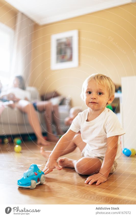 Toddler playing in living room boy toddler baby home pensive family parent childhood game rest innocent blond toy kid at home relax weekend activity apartment