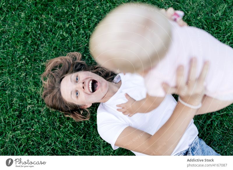 Mother cuddling surprised child in park mother adorable cute funny infant embrace cuddle weekend cheerful happy blond bonding together childhood laugh content