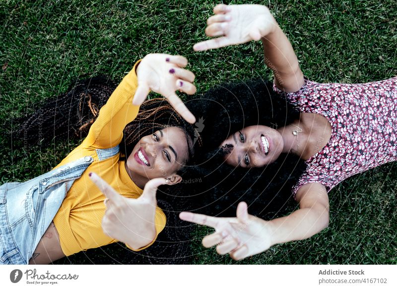Content black women on grass in park friendship lying content girlfriend together smile summer ethnic african american weekend carefree joy delight positive