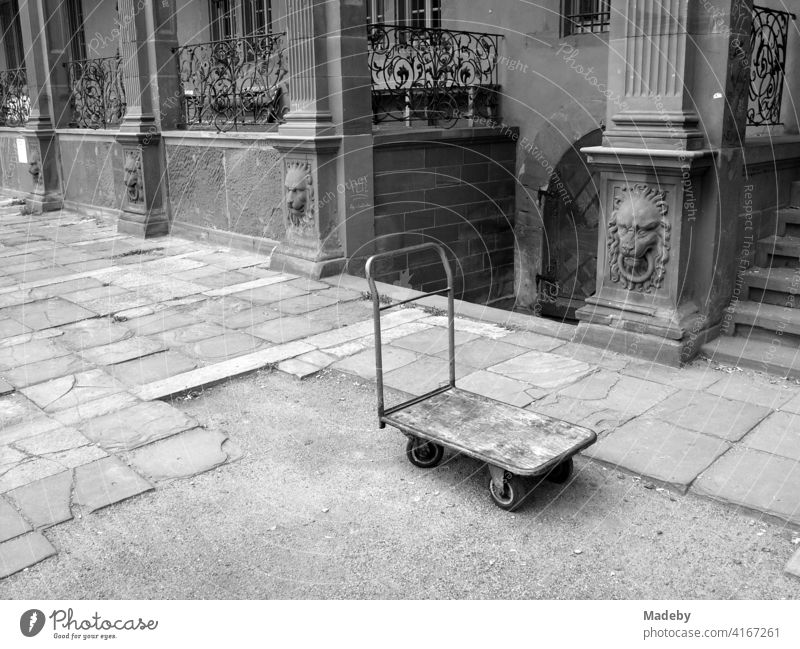 Old platform wagon in the courtyard in front of the Ysenburg Castle in Offenbach am Main in Hesse, photographed in classic black and white magazine trolley