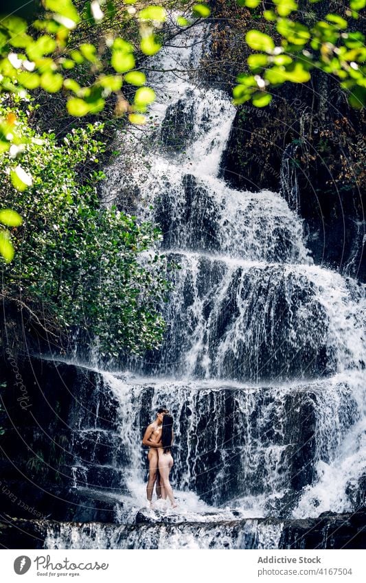 Naked couple hugging near waterfall naked nude vacation together erotic embrace tender summer kiss kissing romantic love relationship intimate nature girlfriend