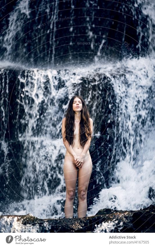 Naked woman near waterfall in summer nude nature carefree tranquil naked cover body freedom female enjoy pleasure peaceful idyllic sensual eyes closed serene