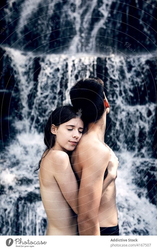 Tender naked couple embracing near waterfall tender hug nature love nude carefree embrace summer affection romantic together enjoy relationship sensual harmony