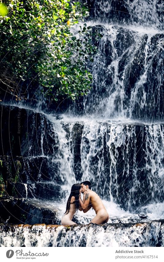 Naked couple hugging near waterfall naked nude vacation together erotic embrace tender summer romantic love relationship intimate nature girlfriend harmony