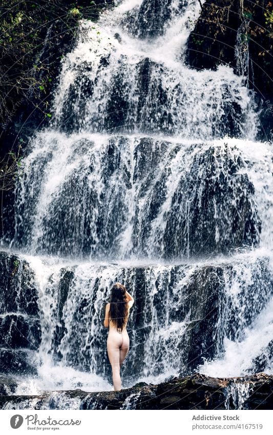 Naked woman near waterfall in summer nude nature carefree tranquil naked body freedom female enjoy pleasure peaceful idyllic sensual serene relax harmony fresh