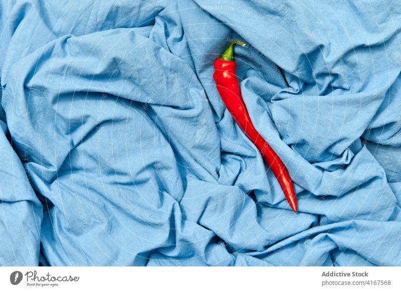 Colorful red chili pepper on crumpled fabric spicy vegetable still life fresh ripe colorful ingredient raw natural organic product vegetarian shiny peel creased