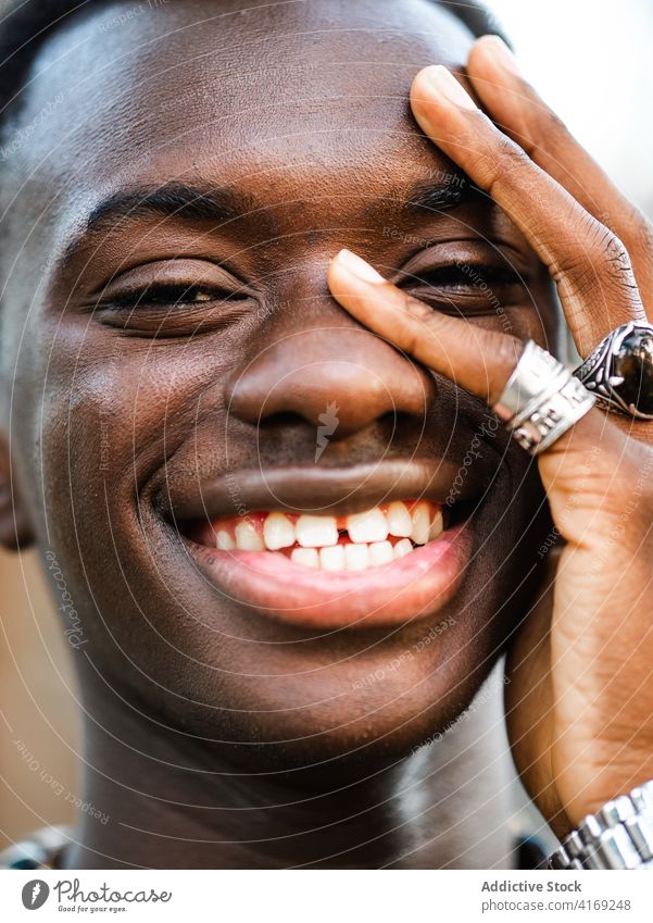 Cheerful black man looking at camera cheerful portrait handsome individuality smile appearance young millennial happy male ethnic african american trendy ring