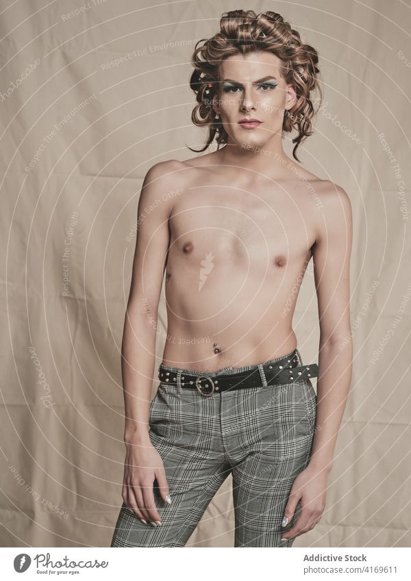 Shirtless androgynous guy with elegant hairdo man makeup shirtless style curly hair slim transgender male young model queer lgbtq fashion glamour appearance