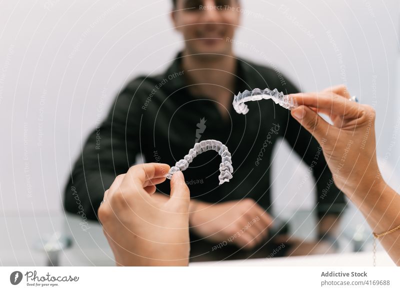 Dentist's hands showing invisible orthodontics to your patient tooth brace dentist care mouth beauty dental dentistry transparent smile orthodontist white young