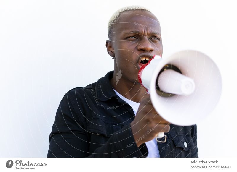 Excited black man with megaphone on white background loudspeaker shout horn announce crazy excited cheerful male ethnic african american gesture achieve scream