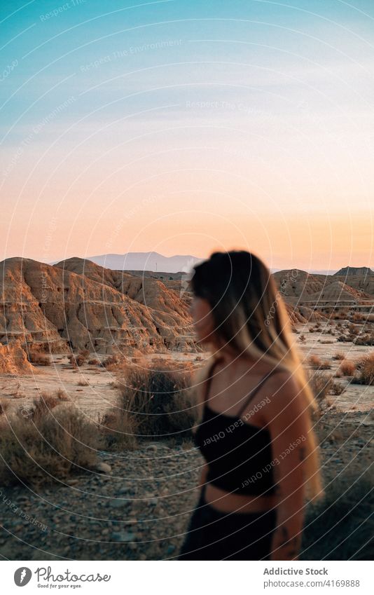 Delighted woman enjoying summer vacation in desert bardenas reales traveler sunset tourism valley dry female spain sunlight nature happy young carefree smile