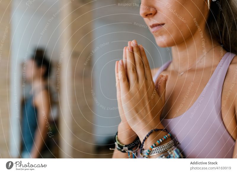 Anonymous woman meditating during yoga lesson meditate studio hands clasped practice zen spirit female young group balance vitality wellbeing relax calm harmony