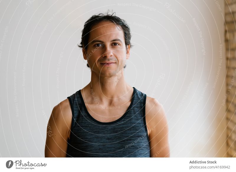 Man looking at camera in yoga studio man lesson break appearance practice relax calm healthy male adult ethnic modern vitality peaceful lifestyle wellbeing