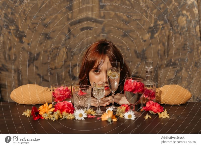 Woman and composition with flowers and glassware woman wineglass sad lonely drink pensive redhead young female floral style ginger lady upset unhappy melancholy