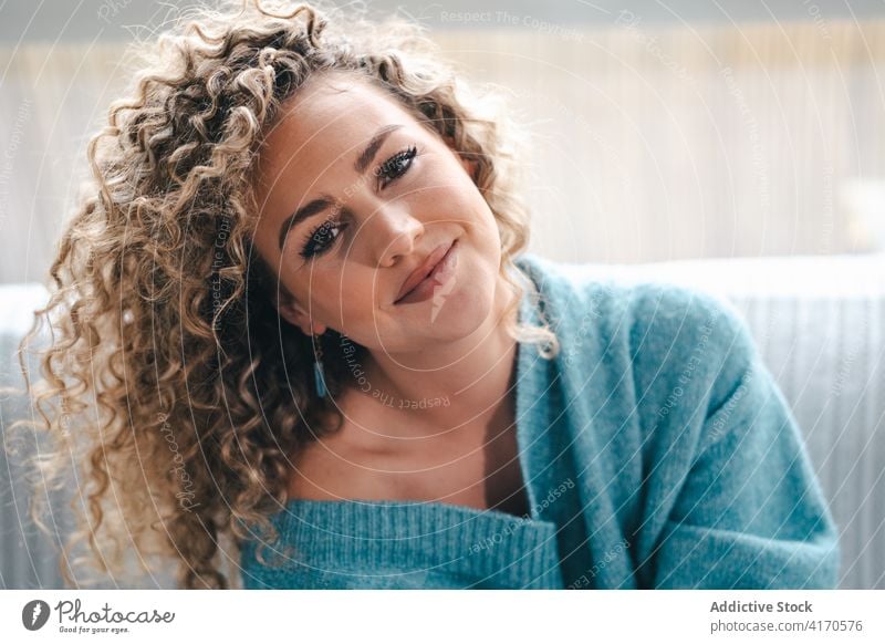 Charming woman in sweater at home coquette cozy knitted curly hair appearance charming style female comfort warm trendy smile tranquil calm modern peaceful