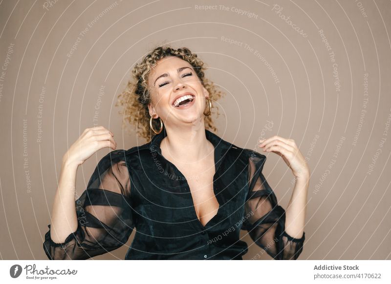 Positive woman laughing in studio having fun candid sincere positive style eyes closed curly hair afro female hairstyle cheerful happy glad carefree relax joy