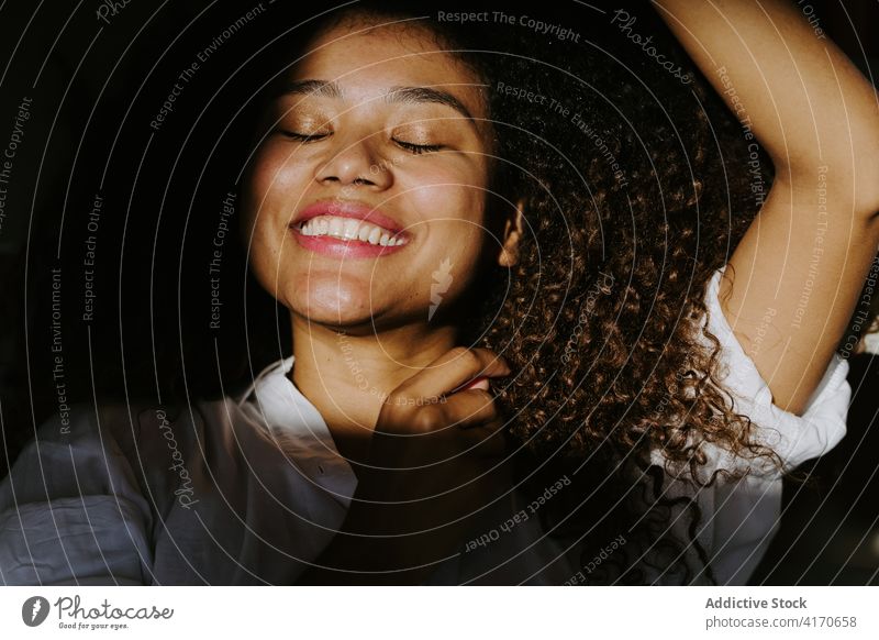 Tranquil ethnic woman in sunlight hair afro hairstyle relax tranquil calm young african american black female gorgeous shade hairdo curly hair long hair