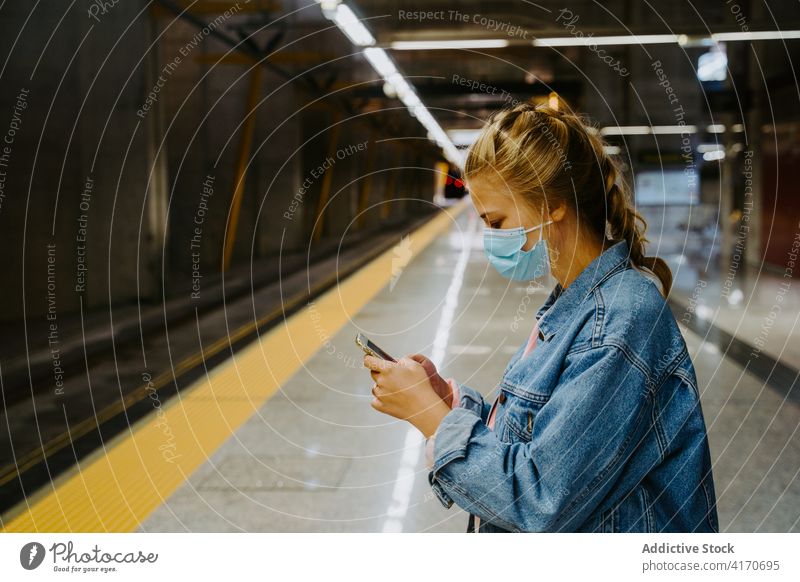 Woman in mask on smartphone at train station woman passenger using cellphone coronavirus railway texting journey female covid covid19 covid 19 transport device