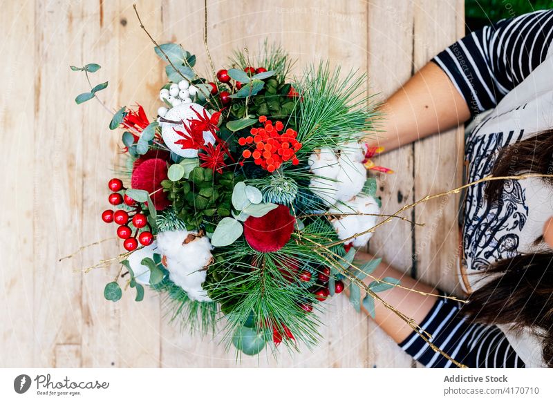 Anonymous woman with christmas flower bouquet in shop holiday store festive illumination xmas florist bloom street celebration ornaments december design fairy