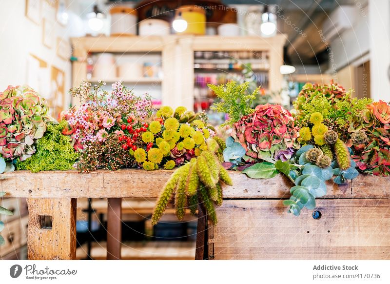 Wooden table at floristry workshop full of flowers for arrangements store bloom bouquet celebration ornaments decoration horizontal spruce wooden compose plant