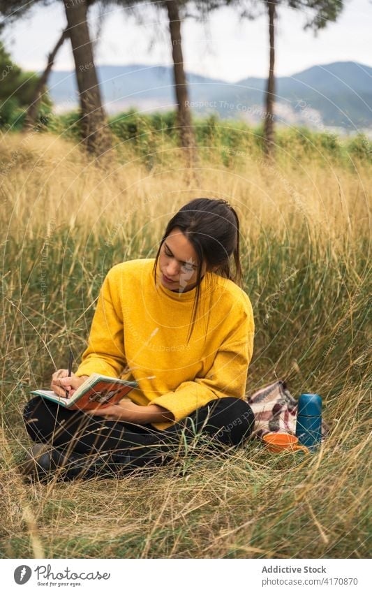 Woman taking notes in notebook in nature take note woman diary write relax thoughtful reflect peaceful female meadow dry calm countryside weekend tranquil