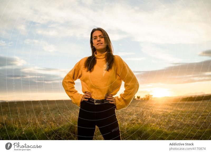 Happy woman standing in field at sunset carefree freedom enjoy smile countryside female outfit casual meadow rural area active happy autumn fall season lady
