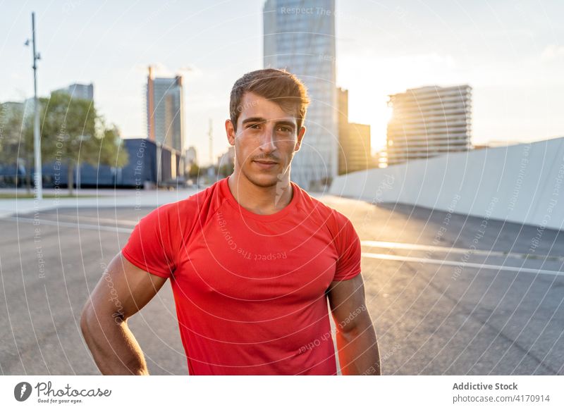 Crop muscular sportsman after working out on the street muscle abdomen masculine macho haircut roadway sky city healthy lifestyle break evening wellness