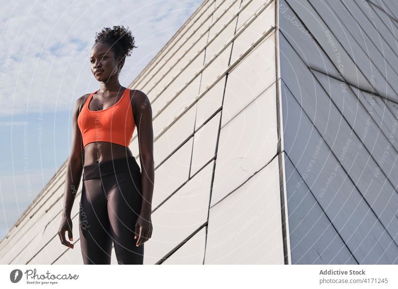 Focused black female athlete on street during training sportswoman slim city fit determine geometry construction shape serious ethnic african american