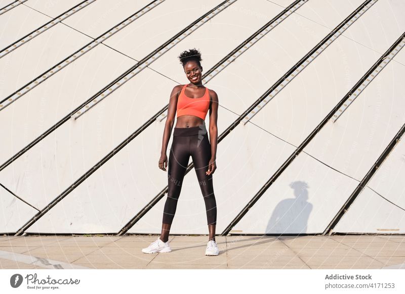 Black sportswoman in street on sunny day athlete city smile slim fit cheerful female ethnic black african american sportswear urban modern workout healthy