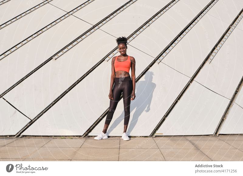 Black sportswoman in street on sunny day athlete city smile slim fit cheerful female ethnic black african american sportswear urban modern workout healthy