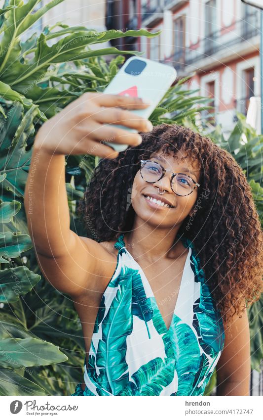 african girl making a selfie with her smartphone woman female young mobile phone afro happy happiness black lifestyle smile smiling curly smart phone