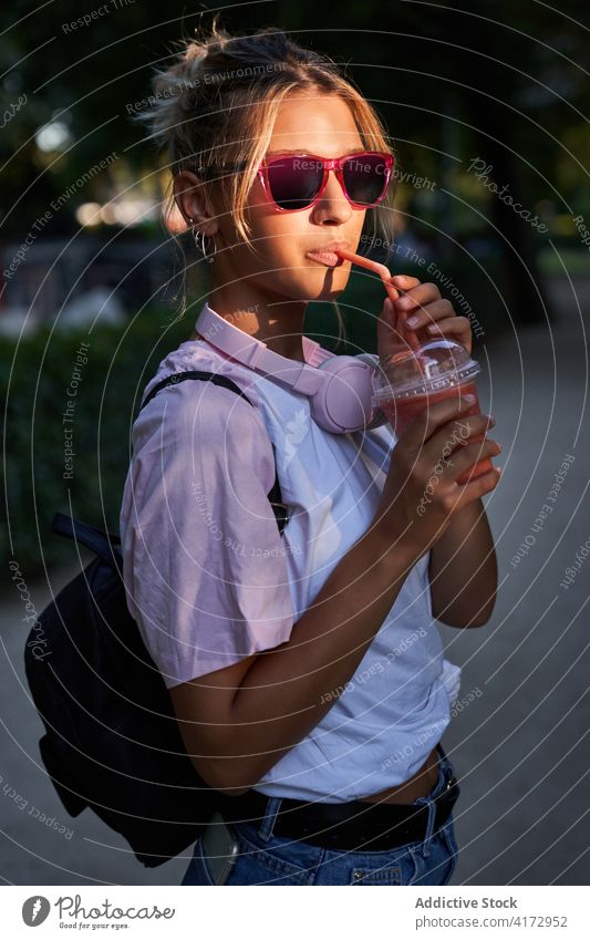 Young woman with sunglasses drinking milkshake in park summer rest hipster teen enjoy female teenage lifestyle young trendy cool teenager relax millennial