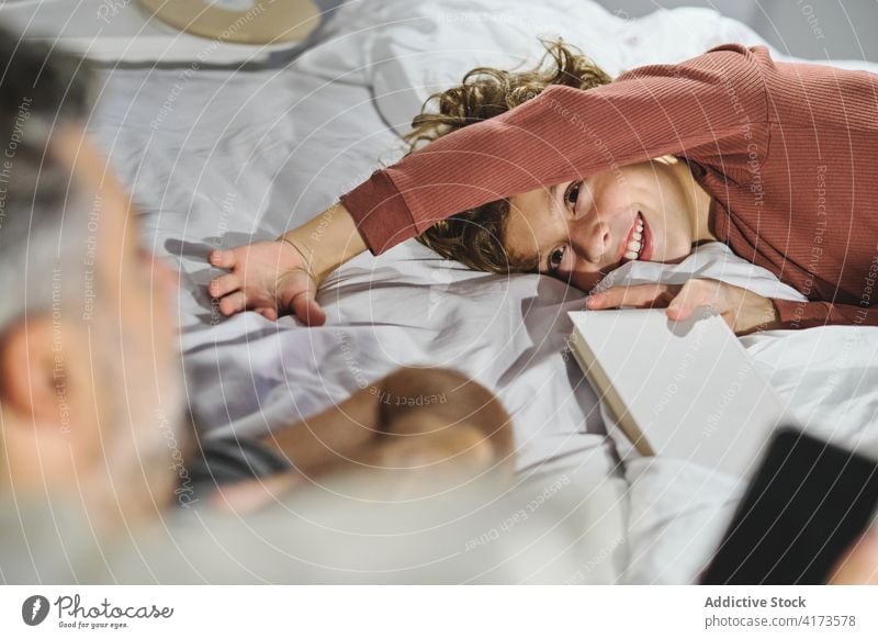 Delighted son playing with father in bedroom laugh tickle having fun weekend together fatherhood childhood lying boy cheerful love bonding affection parent