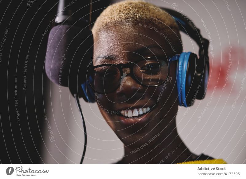 Positive female radio host in studio broadcast station woman speak microphone on air delight ethnic black african american talk live dark work job professional