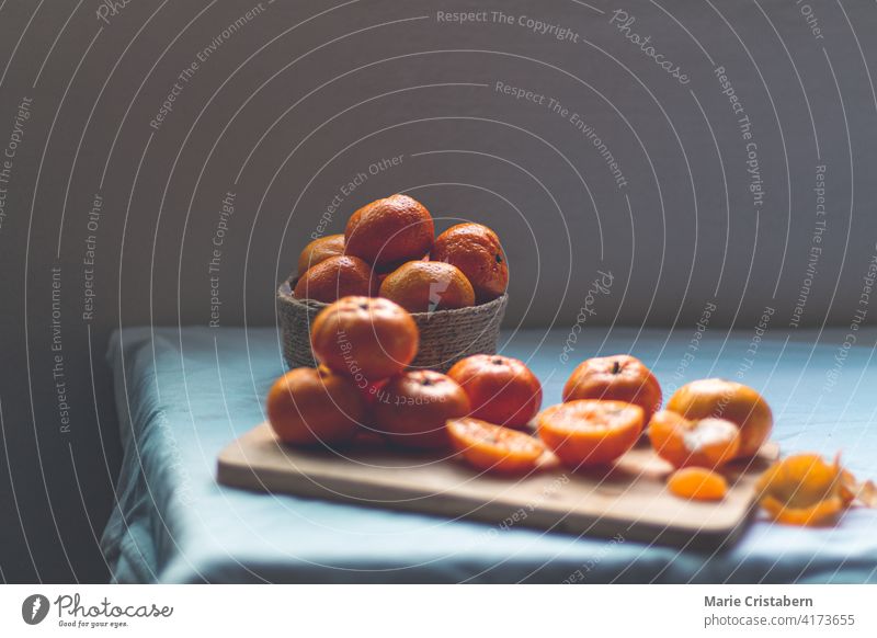 Low light still life photo of fresh clementine oranges low light dark and moody conceptual no people copy space sparse rustic autumn organic vitamin vegetarian