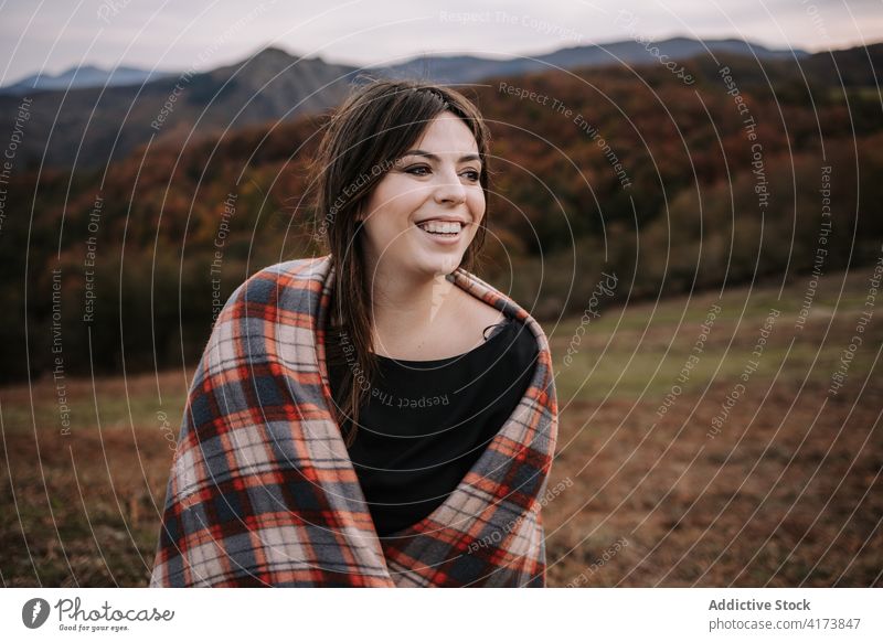 Charming woman in plaid in mountains blanket wrap cozy highland autumn enjoy travel female checkered warm happy smile hill cheerful wanderlust adventure cold