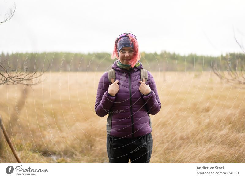 Smiling female traveler in dry field on cold day woman dried explore smile adventure backpacker pink hair sestroretsk saint petersburg russia russian federation