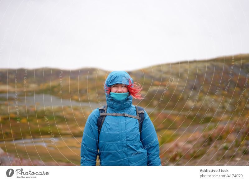 Traveling woman hiking in highlands near sea hike traveler trekking autumn rocky terrain explorer backpack cold female weather warm clothes fall hiker trip