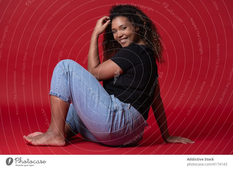 Cheerful plus size female model in casual outfit woman fashion overweight jeans happy cheerful style smile young african american black ethnic barefoot positive