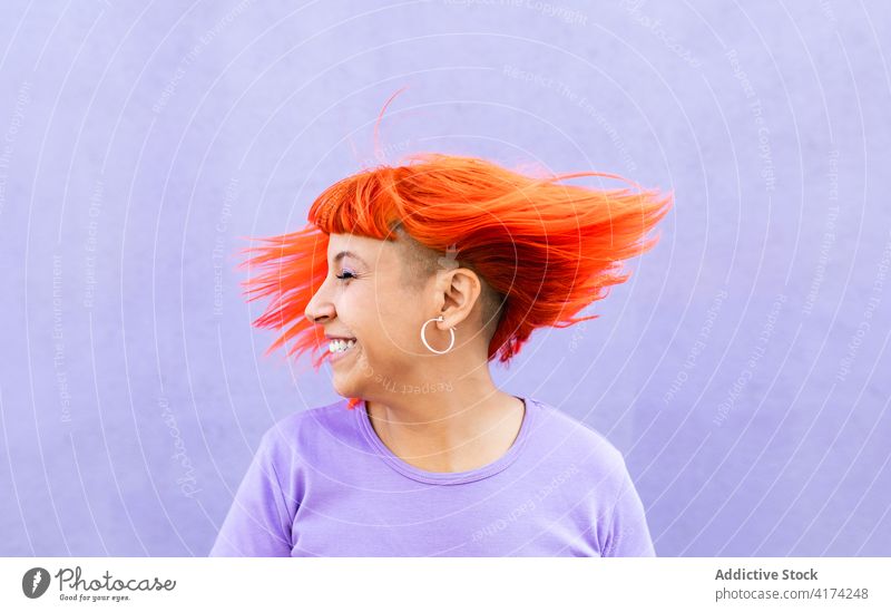 Delighted woman shaking red hair shaking hair happy style rebel dyed hair ginger fun colorful bright female adult millennial subculture excited vibrant urban