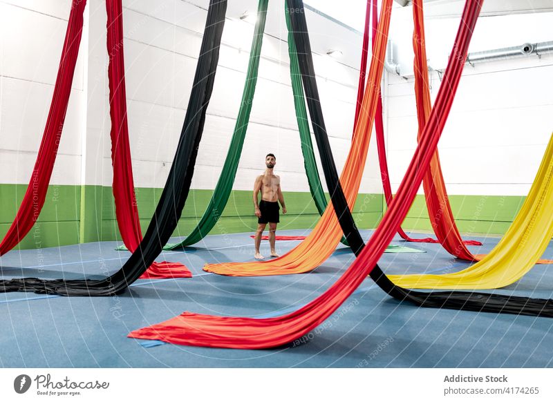 Shirtless man looking at aerial silks dancer studio admire rehearsal choreography gymnast male acrobatic shirtless ribbon perform practice colorful cloth skill