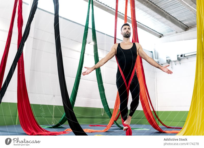 Bearded dancer balancing on aerial silks man balance studio rehearsal gymnastic acrobatic hang male shirtless ribbon adult fabric barefoot skill flexible
