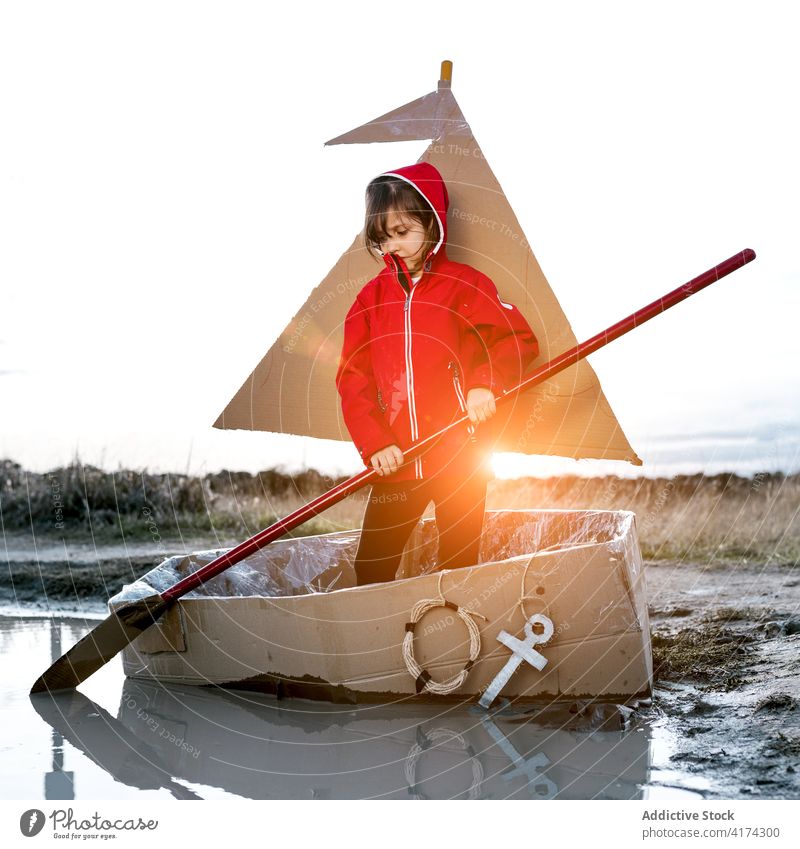 Playful girl in carton boat in countryside cardboard together paddle having fun row child play inspiration game creative imagination handmade enjoy kid