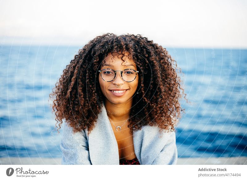 Cheerful black female standing on embankment woman sea smile style weekend happy outfit rest young quay cheerful ethnic african american water delight relax