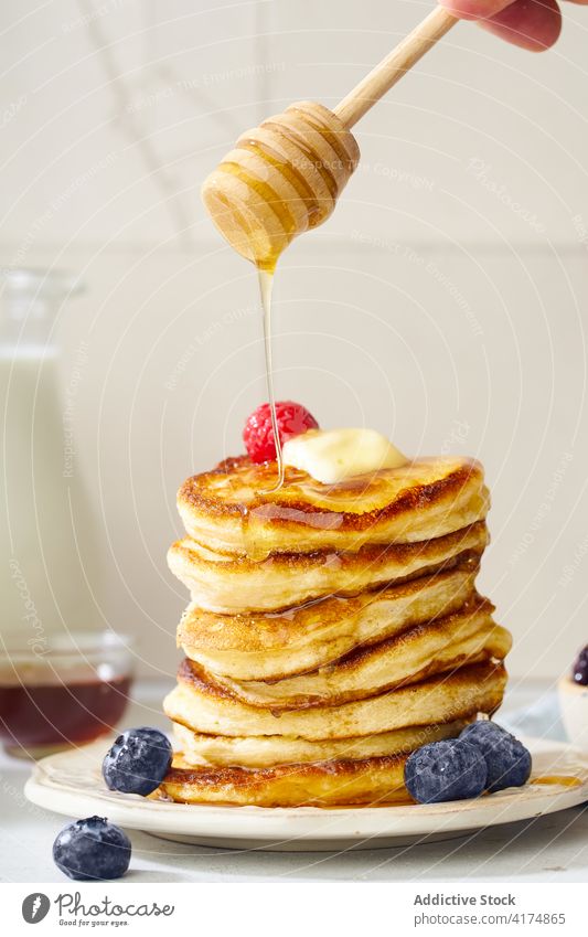 A stack of buttermilk pancakes breakfast food fluffy dessert delicious sirup meal sweet homemade white maple gold plate honey pile fresh morning baked snack