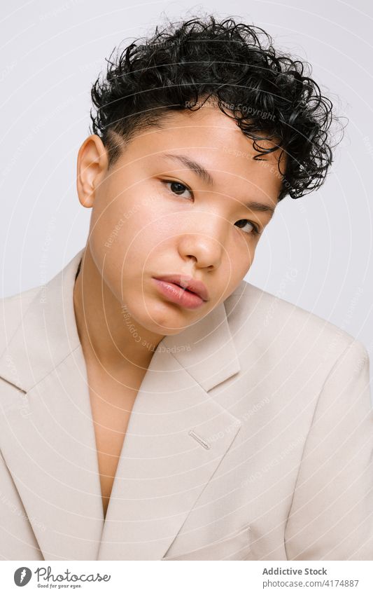 Young Latina woman with her head bowed, wearing a beige blazer diversity beauty latina portrait bowed head young multicultural powerful success natural beauty