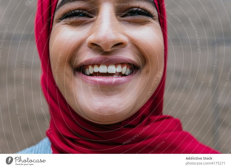 Delighted ethnic woman in hijab laughing in city muslim appearance charming face expression cheerful headscarf having fun female arab joy glad happy optimist