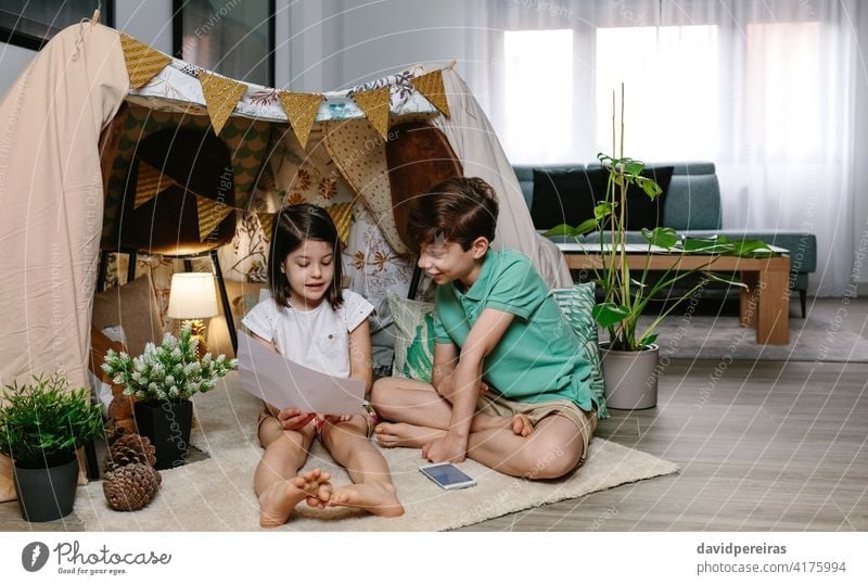 Boy and girl playing in a diy tent at home staycation fun at home stay at home living room boy family lockdown happy home vacation homely leisure camp children
